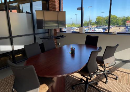 six office chairs surround a brown table with a TV and the Union parking garage can be seen in the background